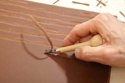 1. Z płyty linoleum wycinamy kwadrat o boku 30 cm. Następnie, posługując się dłutami o wklęsłych ostrzach w kształcie litery U, wycinamy w przybliżeniu równoległe i równomiernie rozmieszczone względem siebie rowki (narzędzia i materiał można kupić w sklepach z artykułami zdobniczymi).